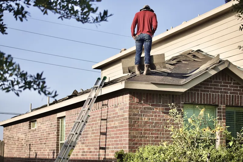 Professional roofer working on a residential roof in Durham Center